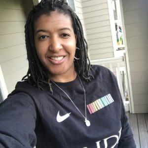 A woman with dreadlocks wearing a black shirt.