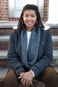 A woman sitting on steps wearing a scarf.