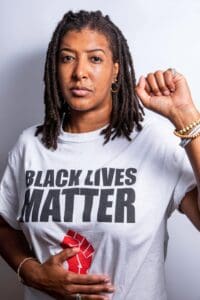 A woman wearing a black lives matter shirt.